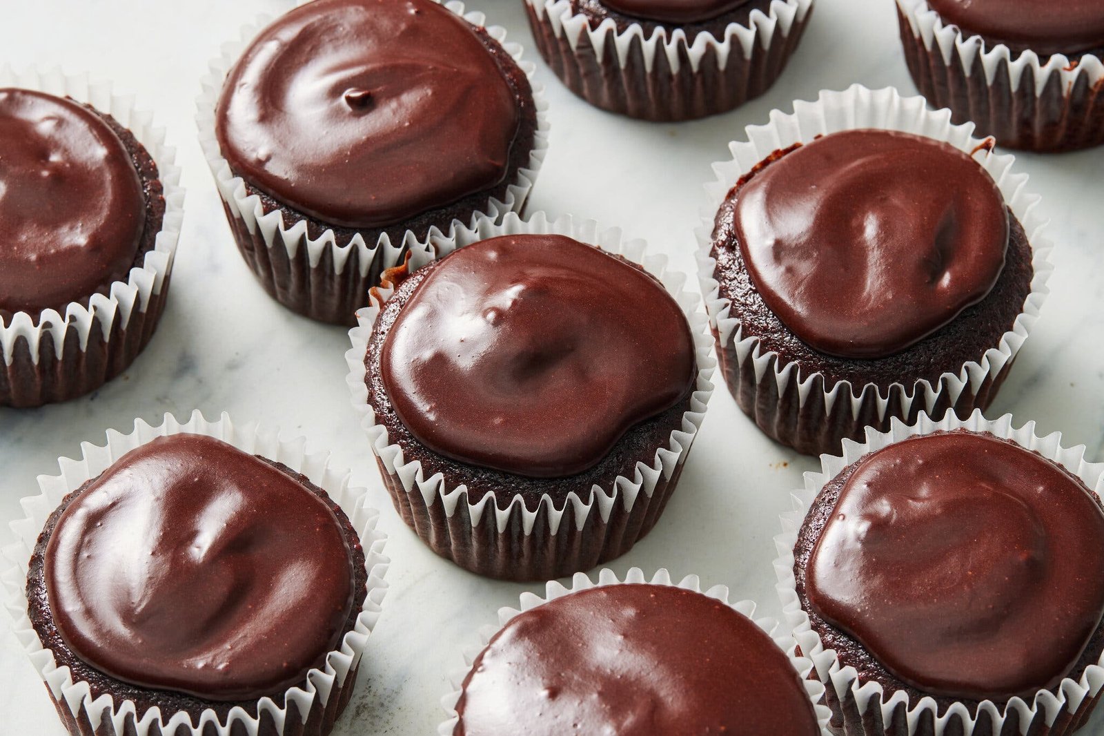 Nine chocolate cupcakes with chocolate glaze.