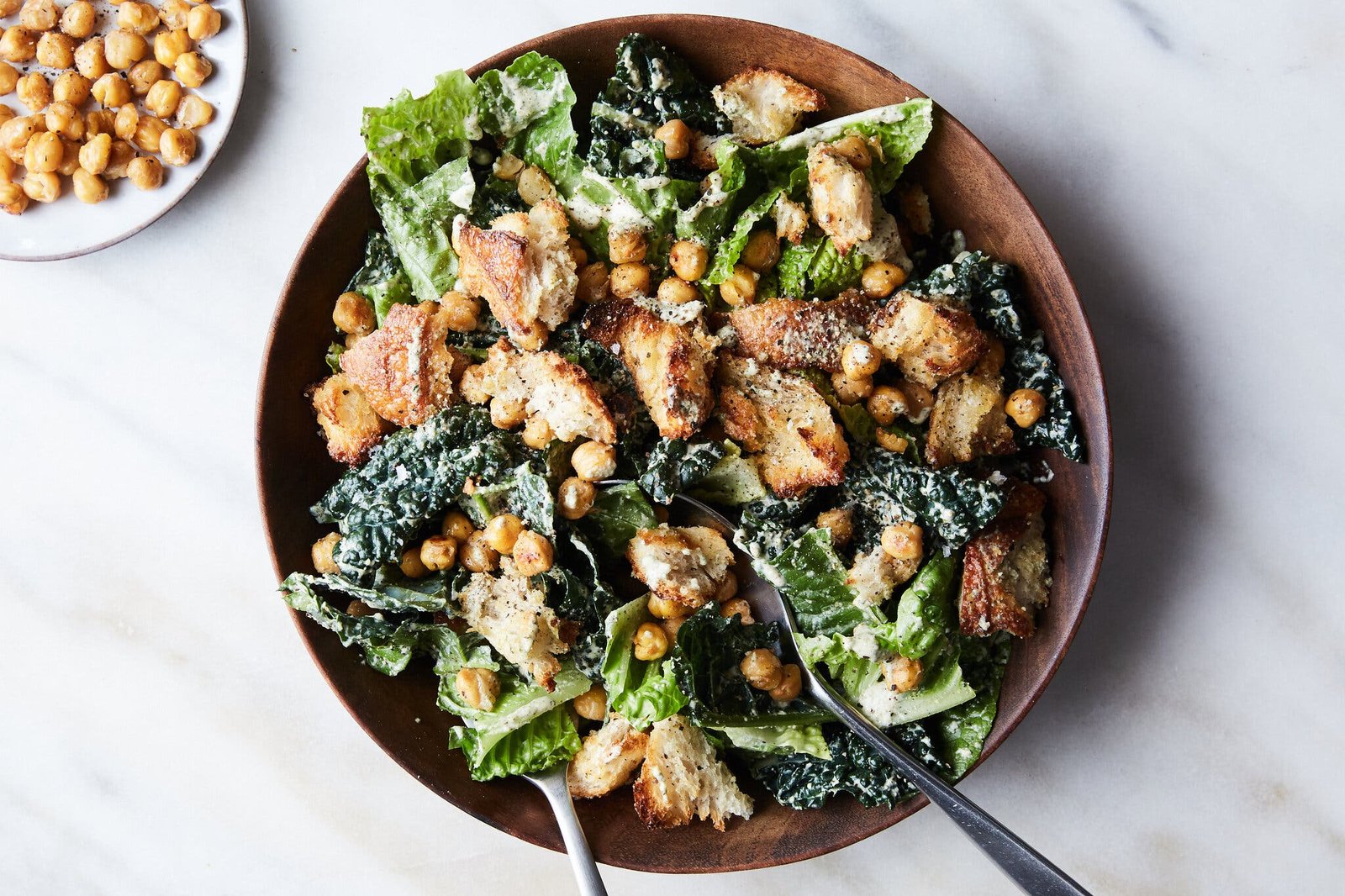 An overhead image of a platter topped with a chickpea and breadcrumb filled Caesar salad.