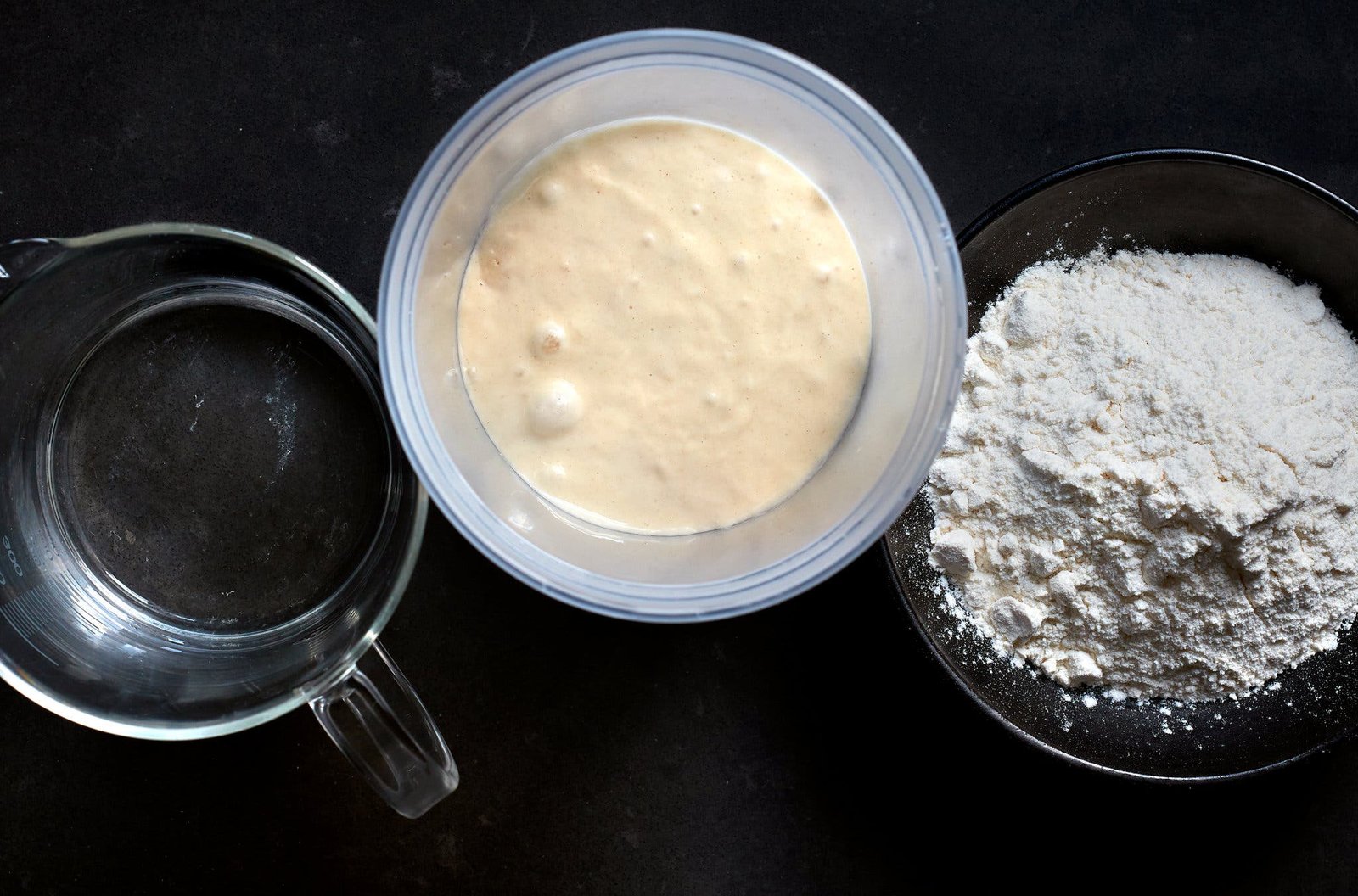 An overhead image of water, sourdough starter and flour.