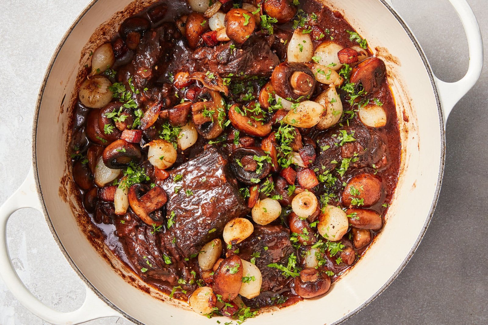 A pot of beef stew on a white countertop.