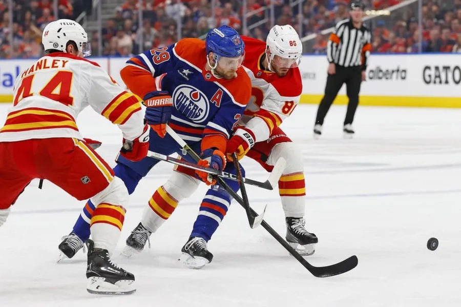 Mar 29, 2025; Edmonton, Alberta, CAN; Edmonton Oilers forward Leon Draisaitl (29) and Calgary Flames forward Joel Farabee (86) battle for a loose puck during the first period at Rogers Place. Mandatory Credit: Perry Nelson-Imagn Images