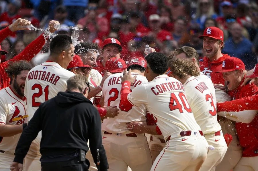 Apr 26, 2025; St. Louis, Missouri, USA; St. Louis Cardinals third baseman Nolan Arenado (28) is mobbed by teammates after hitting a solo walk-off home run against the Milwaukee Brewers during the ninth inning at Busch Stadium. Mandatory Credit: Jeff Curry-Imagn Images
