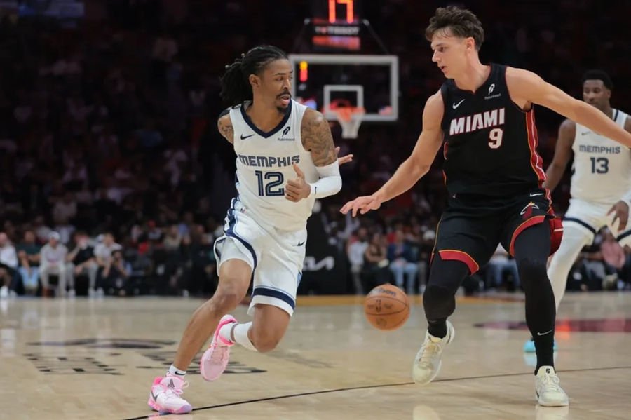 Apr 3, 2025; Miami, Florida, USA; Memphis Grizzlies guard Ja Morant (12) passes the basketball as Miami Heat guard Pelle Larsson (9) defends during the second quarter at Kaseya Center. Mandatory Credit: Sam Navarro-Imagn Images