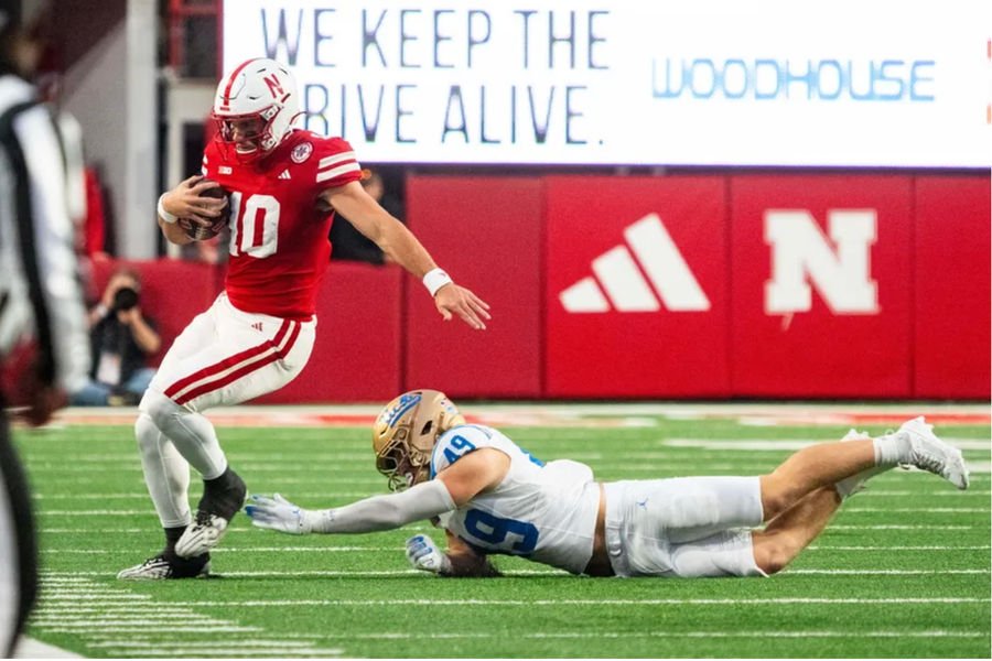 Nov 2, 2024; Lincoln, Nebraska, USA; Nebraska Cornhuskers quarterback Heinrich Haarberg (10) runs out of bounds against UCLA Bruins linebacker Carson Schwesinger (49) during the fourth quarter at Memorial Stadium. Mandatory Credit: Dylan Widger-Imagn Images