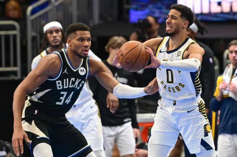 Nov 22, 2024; Milwaukee, Wisconsin, USA; Indiana Pacers guard Tyrese Haliburton (0) looks to pass the ball away from Milwaukee Bucks forward Giannis Antetokounmpo (34) in the third quarter at Fiserv Forum. Mandatory Credit: Benny Sieu-Imagn Images