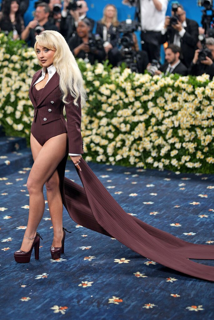 Sabrina Carpenter wearing an espresso-brown double-breasted bodysuit with a long tailcoat train.