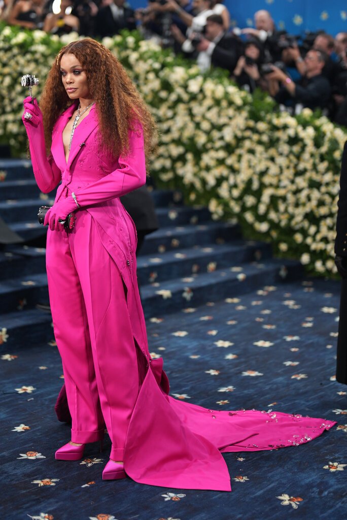 Andra Day wearing a hot pink suit, with gloved sleeves and an embellished train.